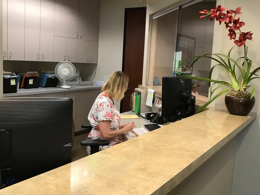The reception desk at the practice, with an orchid on the counter.